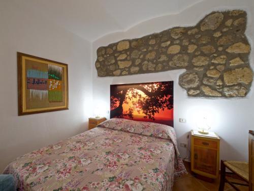 um quarto com uma cama e uma parede de pedra em B&B ai Castagni em Bagnore