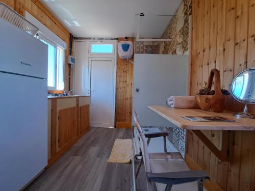 uma cozinha com um balcão, uma mesa e uma cadeira em Tiny house camión fijo en Islas Canarias em Triquivijate