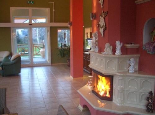 a living room with a fireplace in the middle at Hotel Krak in Myślenice
