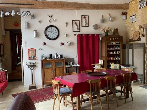 une salle à manger avec une table et une horloge au mur dans l'établissement Chambre d'Hôtes du Domaine de la Haute Poignandiere, à Saint-Germain-de-la-Coudre