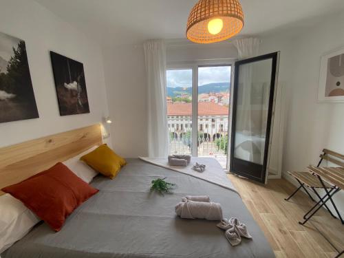 a bedroom with a large bed with a large window at ETXIE LA CASA TARASKA in Bermeo