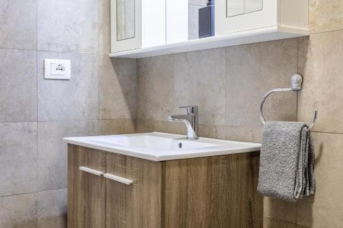 a bathroom with a white sink and a mirror at Divi Apartments Milano - Strategic Place in Milan