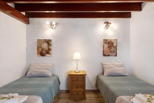 Zimmer mit 2 Betten und einem Tisch mit einer Lampe in der Unterkunft Casita Ana in El Paso