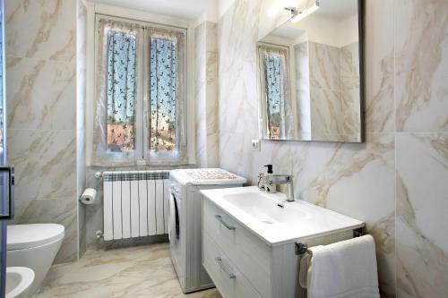 uma casa de banho com um lavatório, um WC e janelas em Casa Global Atlantica em Nova Milanese