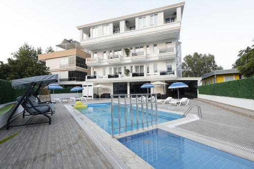 a hotel with a swimming pool in front of a building at Mira Hotel Antalya in Antalya