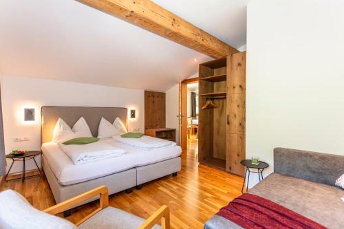 ein Schlafzimmer mit einem Bett und einem Stuhl in einem Zimmer in der Unterkunft Apartment Landhaus Buchner in Zell am See