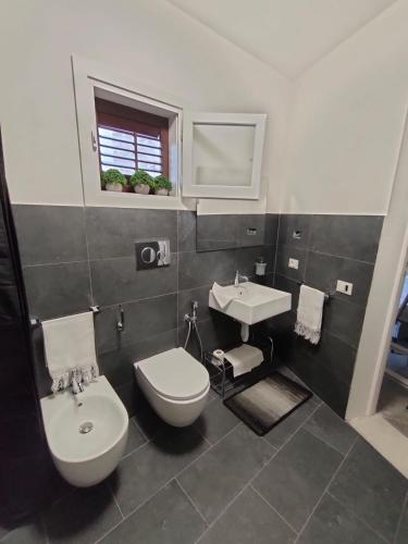 a bathroom with a toilet and a sink at Cave Bianche Apartments in Favignana