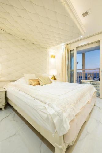 a white bedroom with a large bed with a window at Reimi Mondo9 in Tokyo