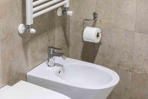 a bathroom with a sink and a roll of toilet paper at Divi Apartments Milano - Strategic Place in Milan