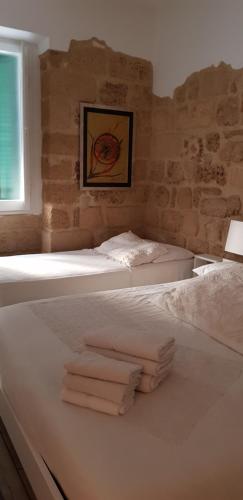 two beds in a room with towels on them at Aliga in Alghero