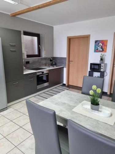 a kitchen with a table and some chairs and a counter at Ferienwohnung beim Nationalpark Eifel in Nideggen