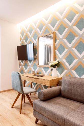 a room with a desk with a mirror and a couch at DAYS City Suites Athens in Athens