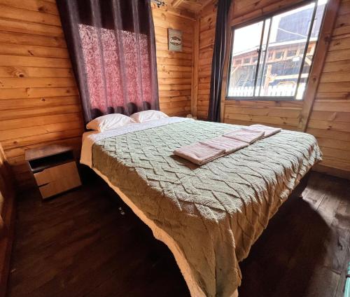 a bedroom with a bed in a wooden cabin at Cabaña Gran torino cajica in Cajicá