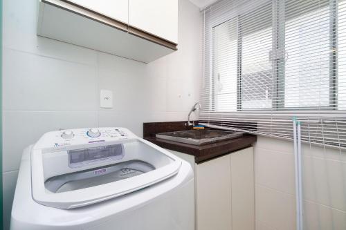 una lavadora en una cocina blanca con fregadero en Aluguel Apartamento 2 quartos c/ 1 suíte | Bombas/SC, en Bombinhas