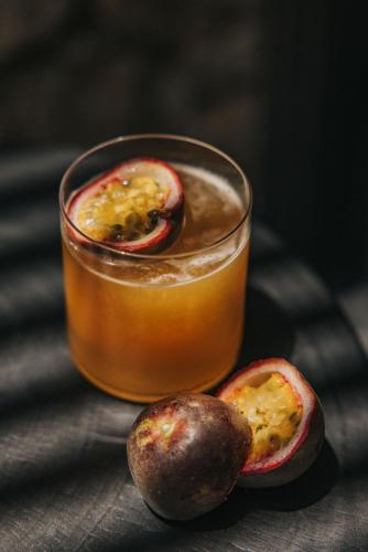 a glass of blood orange juice with two passion fruit halves at Noima Boutique Hotel Mykonos in Agios Ioannis Mykonos