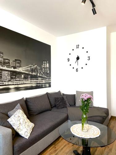 a living room with a couch and a clock on the wall at Z MIŁOŚCI DO GÓR Noclegi in Piechowice