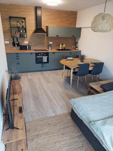 a kitchen and living room with a table and a couch at Apartmán Bešeň 304 in Bešeňová
