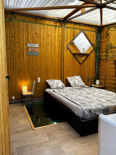 une chambre avec un lit dans un mur en bois dans l'établissement l'aquarium, à Brignoles