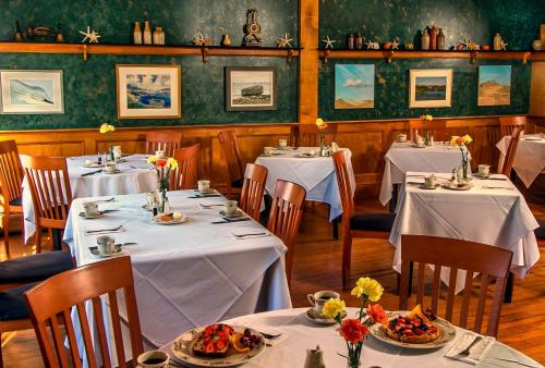 a dining room with tables with white tablecloths at Queen Anne Inn in Chatham