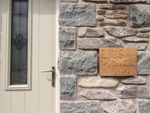 a us immigration sign on a stone wall next to a door at Llys Tirion in Bala