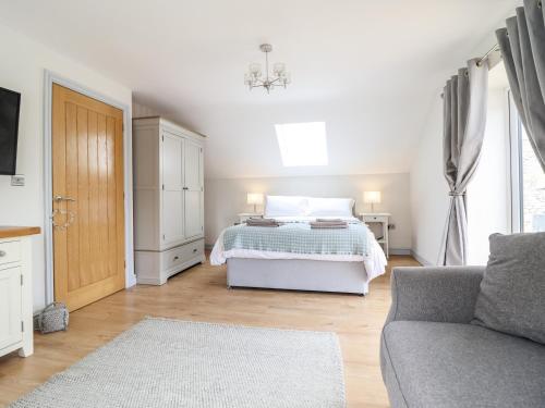a white bedroom with a bed and a couch at Llys Tirion in Bala