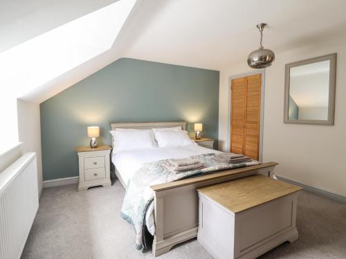 a bedroom with a bed and two tables and a mirror at Llys Tirion in Bala