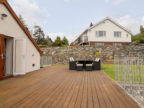a deck with chairs and a table on a house at Llys Tirion in Bala