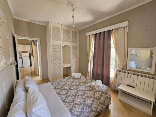 een slaapkamer met een wit bed en een raam bij Tondoris Apartments in Sidari