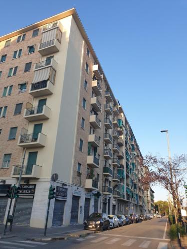 a large apartment building on a street with cars parked at Casa eNNe, Appartamento Vicino Centro e Juventus Stadium in Turin