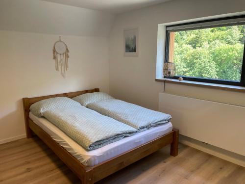 1 dormitorio con 1 cama en una habitación con ventana en Jirotovy boudy I en Telnice