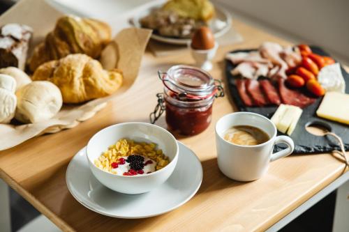 a wooden table with two cups of coffee and pastries at B&B Le Zucche in Belluno