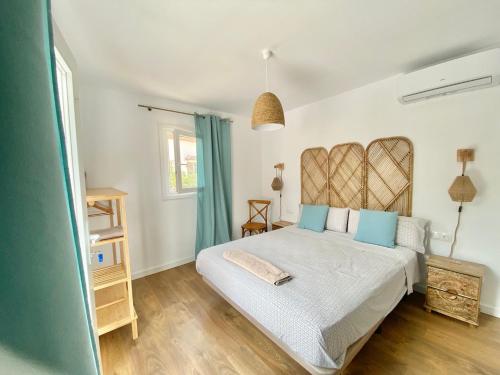 a bedroom with a large white bed with blue pillows at Harmony Home in Alcaucín