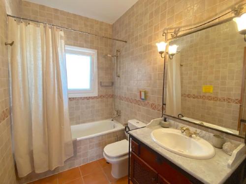 a bathroom with a sink and a toilet and a tub at Harmony Home in Alcaucín