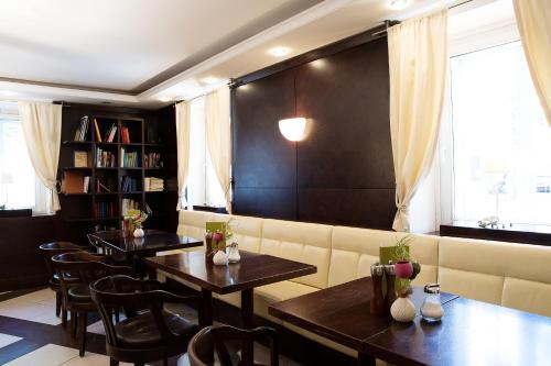 a dining room with two tables and a couch at Hotel Sandwirth in Klagenfurt