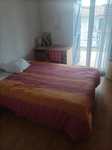 1 dormitorio con cama, escritorio y ventana en CHAMBRE PRIVEE AVEC VUE SUR LA RHUNE, en Urrugne