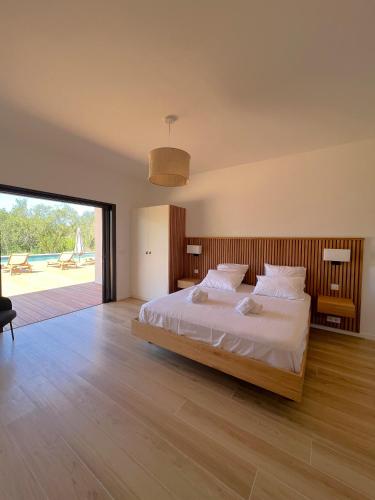 une chambre avec un grand lit et une grande fenêtre dans l'établissement Casa Sandro, à Sainte-Lucie de Porto-Vecchio