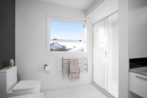 biała łazienka z toaletą i oknem w obiekcie Quality City Appartment w mieście Christchurch