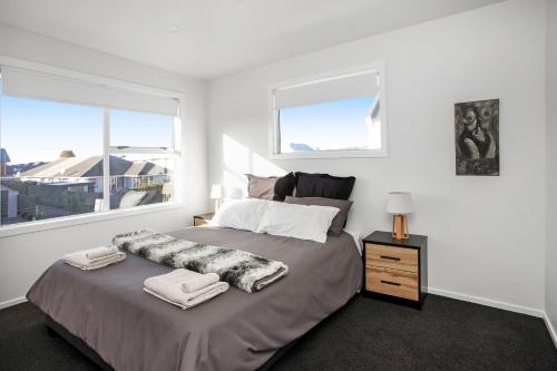 - une chambre avec un grand lit et 2 fenêtres dans l'établissement Quality City Appartment, à Christchurch