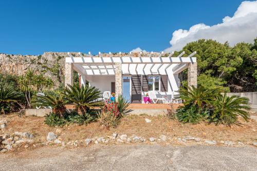 una casa con gente sentada delante de ella en Casa Lia e Nino a San Vito Lo Capo en San Vito lo Capo