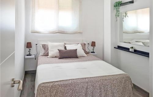 1 dormitorio con 1 cama grande, paredes blancas y espejo en 3 Bedroom Cozy Apartment In La Rpita, en Sant Carles de la Ràpita