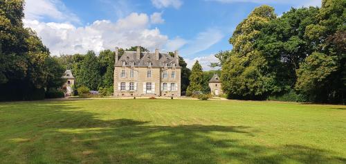 a large house with a large grassy field at chateau du Bois-Riou in Quévert