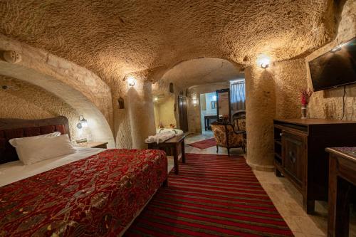 a hotel room with a bed in a cave style room at Shiraz Cave Cappadocia in Ürgüp