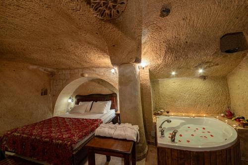 a bedroom with a bed and a bath tub at Shiraz Cave Cappadocia in Urgup