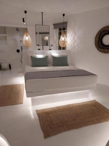 a bedroom with a large bed and two rugs at Altana Boutique Hotel in Tinos Town