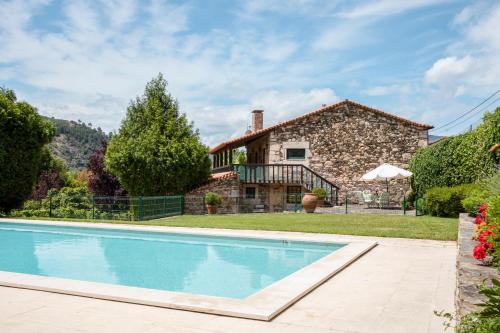 an exterior view of a stone house with a swimming pool at Fonte dos Pepes by LovelyStay in Lamego