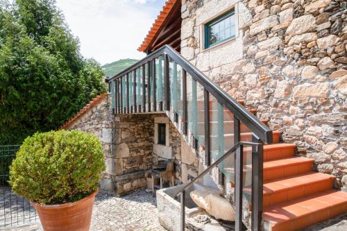 une maison en pierre avec un escalier en face d'un bâtiment dans l'établissement Fonte dos Pepes by LovelyStay, à Lamego