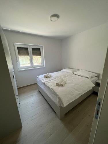 - une chambre blanche avec un lit et une fenêtre dans l'établissement APARTMENTS EDWINA, à Portorož