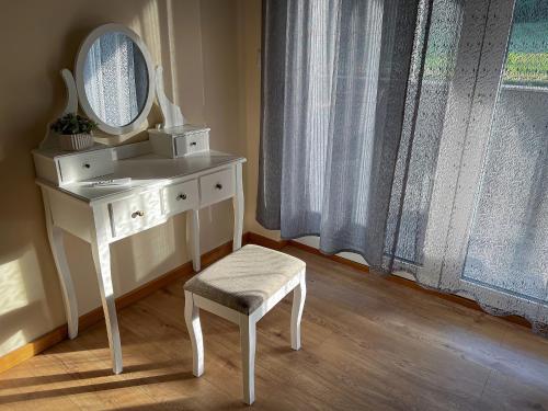a white dressing table with a mirror and a stool at Villa Dora in Krapinske Toplice