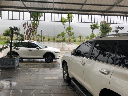 LAS VEGAS HOTEL في كوانغ ننه: سيارتين بيض متوقفتين في موقف للسيارات