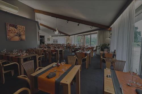 ein Restaurant mit Holztischen und -stühlen in einem Zimmer in der Unterkunft Le Noirlac in Saint-Amand-Montrond